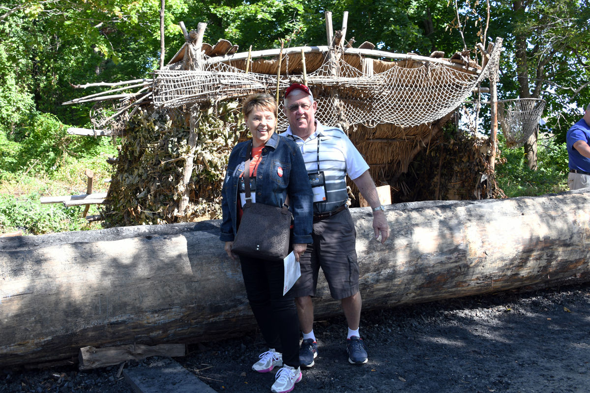 023 Althea and Dick Luethje pose in front of log that will be hollowed out into a canoe.jpg